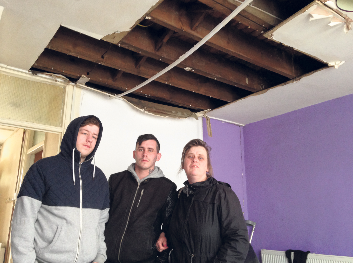 Bridget McCarthy with sons Conor and Ricky, standing under the hole that appeared in their ceiling.