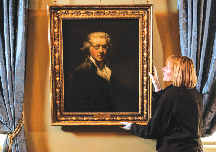Portrait of Reynolds English Heritage curator Louise Cooling positions Joshua Reynold’s self-portrait. The painting features in a new display marking 300 years since the birth of the celebrated