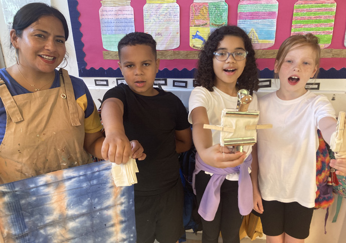 Parent Tatiana Hernandez leading a screen printing class with year 5 students Jaylen Flora and Ruby